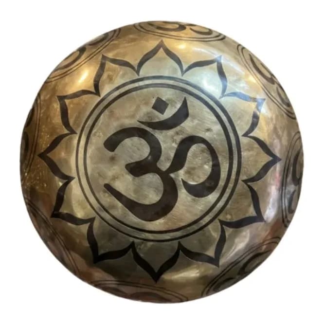 A polished bronze singing bowl etched with an Om symbol